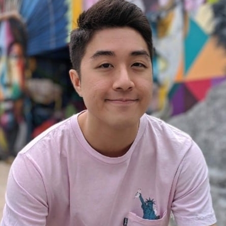 Joel Wong, a young Asian male with black hair wearing a pink t-shirt against a background of graffiti.