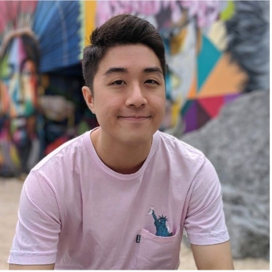 Joel Wong, a young Asian male with black hair wearing a pink t-shirt against a background of graffiti.