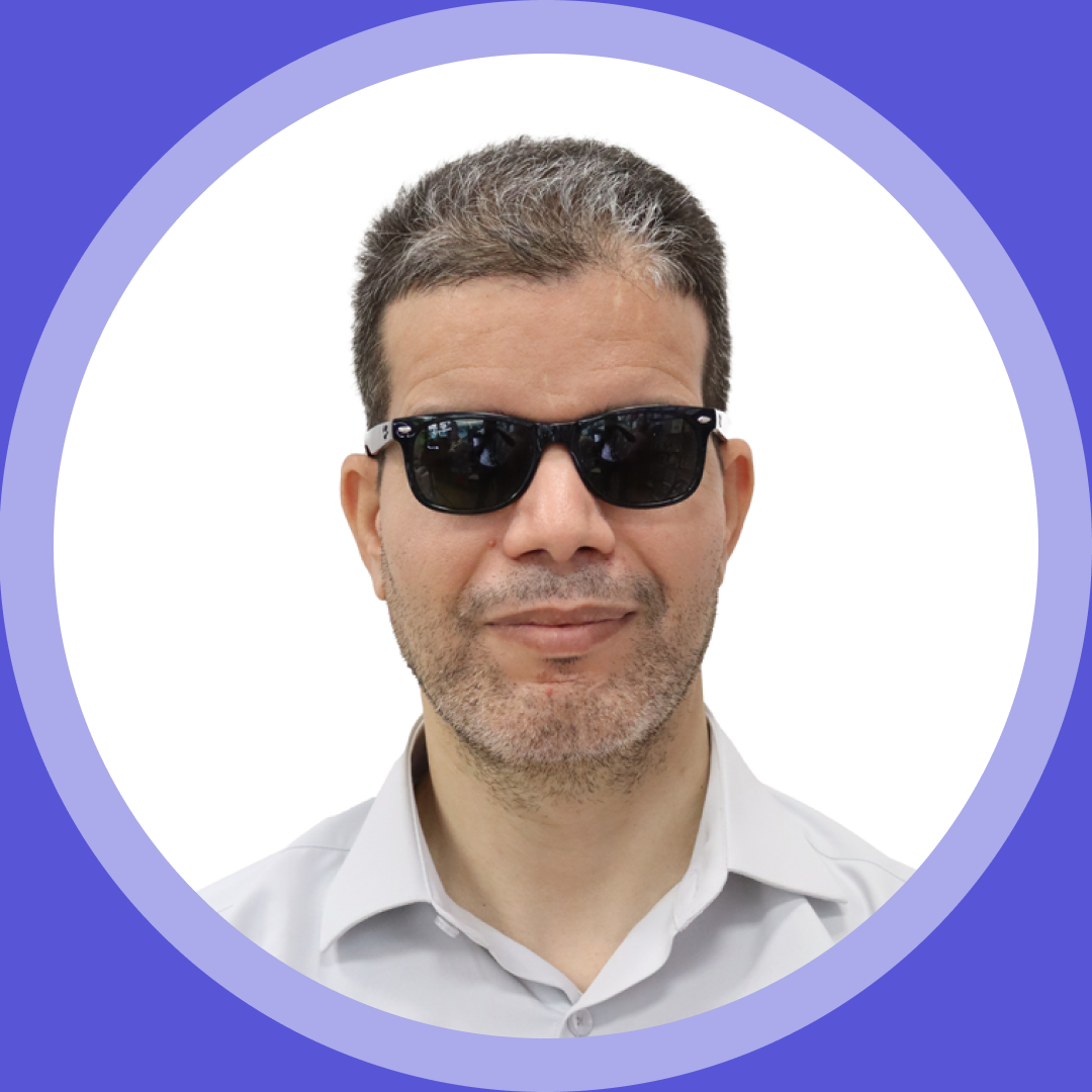 Thumbnail image. Portrait of Hamid A., a man with short, dark hair with some gray, wearing black sunglasses and a light-colored collared shirt, set inside a purple circular frame.