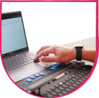 Fable Community Braille Display Hand using a braille display connected to a laptop keyboard