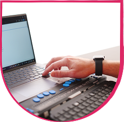 Fable Community Braille Display Hand using a braille display connected to a laptop keyboard